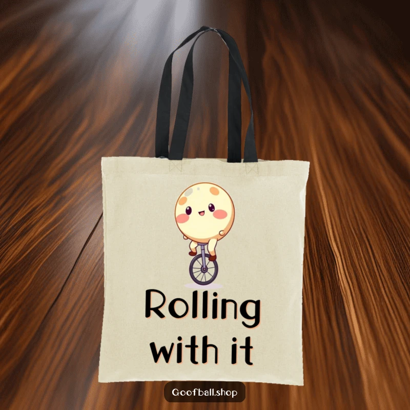 Funny Tote Bag with a round, spotty entity precariously balancing on a unicycle, looking comically unstable.